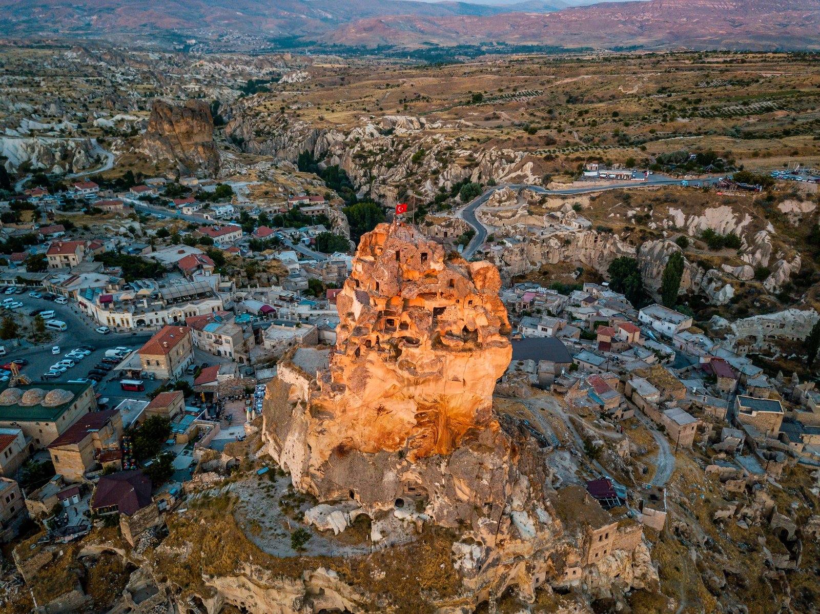 Uchisar Castle surrounded by buildings and rock formations in Cappadocia, Turkey